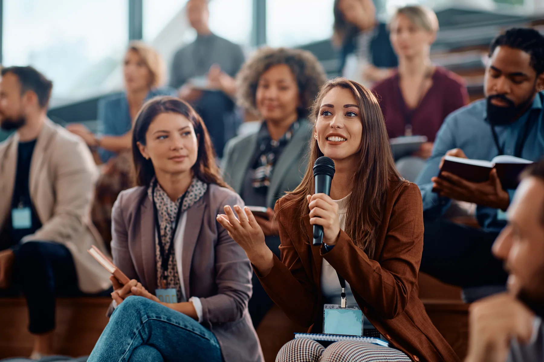 An audience member speaking into a microphone during a conference discussion